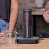 Two people brewing coffee with an AeroPress using the Madcap recipe